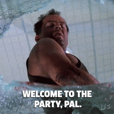 A looping clip from the film "Die Hard", Bruce Willis looking out of a broken window, with the caption "Welcome to the party, pal"