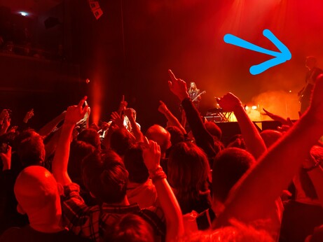 An amateurish photograph of Suede performing live.  Brett Anderson is obscured by the crowd, and Matt Osman is almost out of shot.